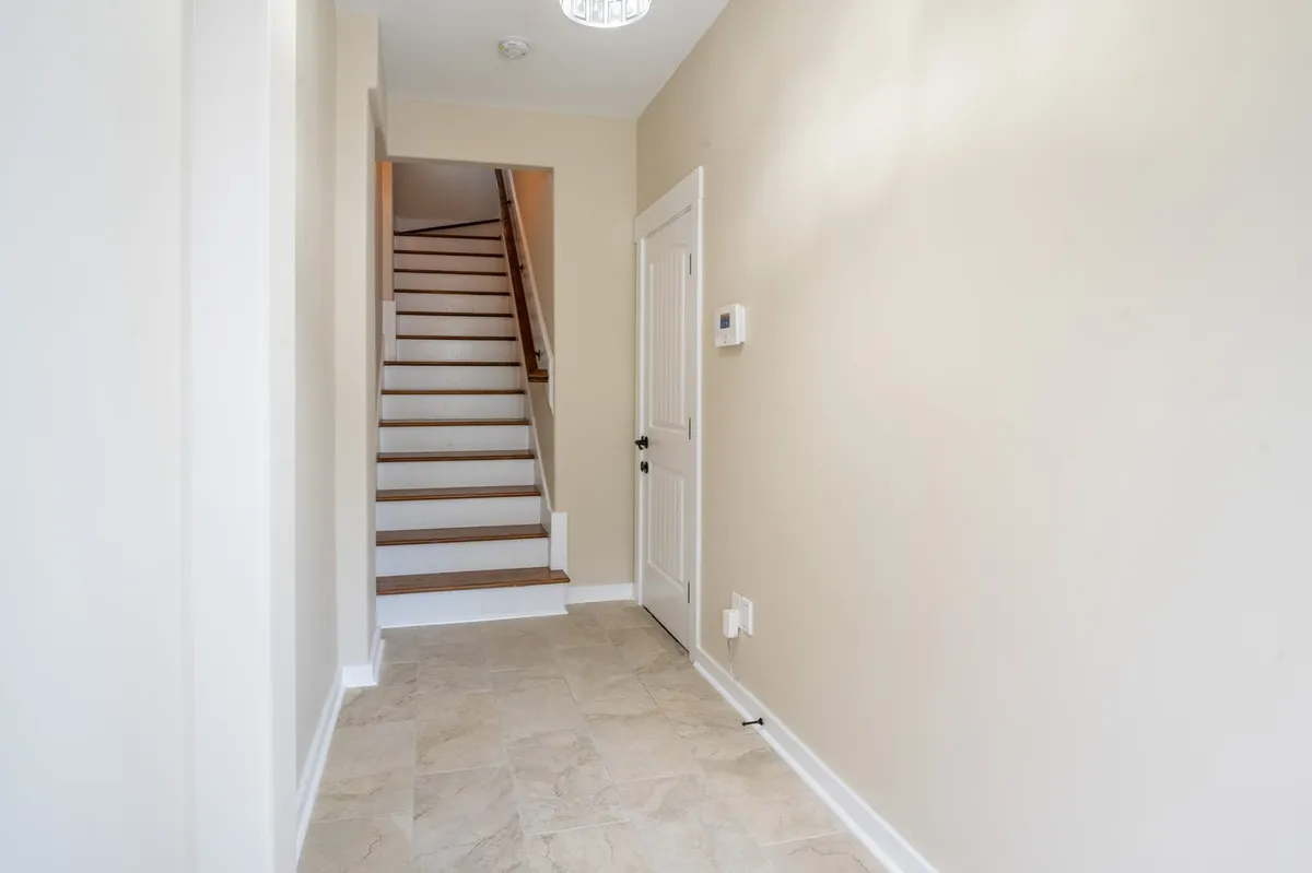 This image captures an inviting staircase and front door, bathed in natural light from the entryway. The scene suggests the moment of arrival, welcoming guests home from a day of adventure and exploration.