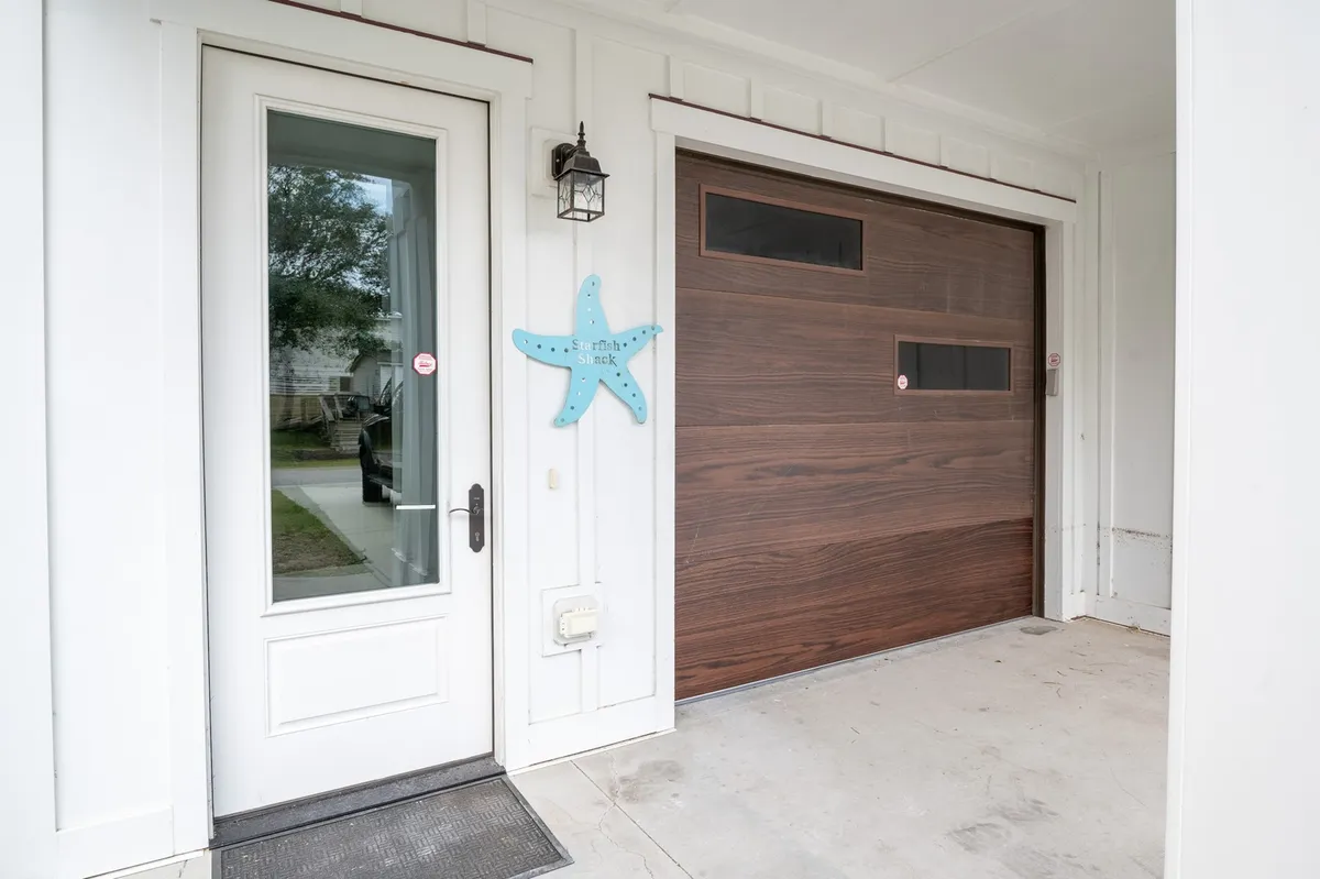 A friendly and inviting entryway featuring both the front door and garage door, accented by a decorative starfish. The space feels welcoming and hints at easy transitions between indoor and garage areas, contributing to the home’s overall accessibility and charm.