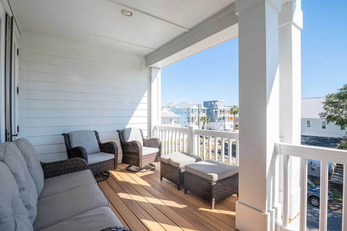 This exterior image showcases a comfortable seating area set atop wooden flooring, with an open view suggesting proximity to nature and the outdoors. The mood is casual, inviting residents to relax, read, or socialize while enjoying fresh air and potentially taking in sunsets.