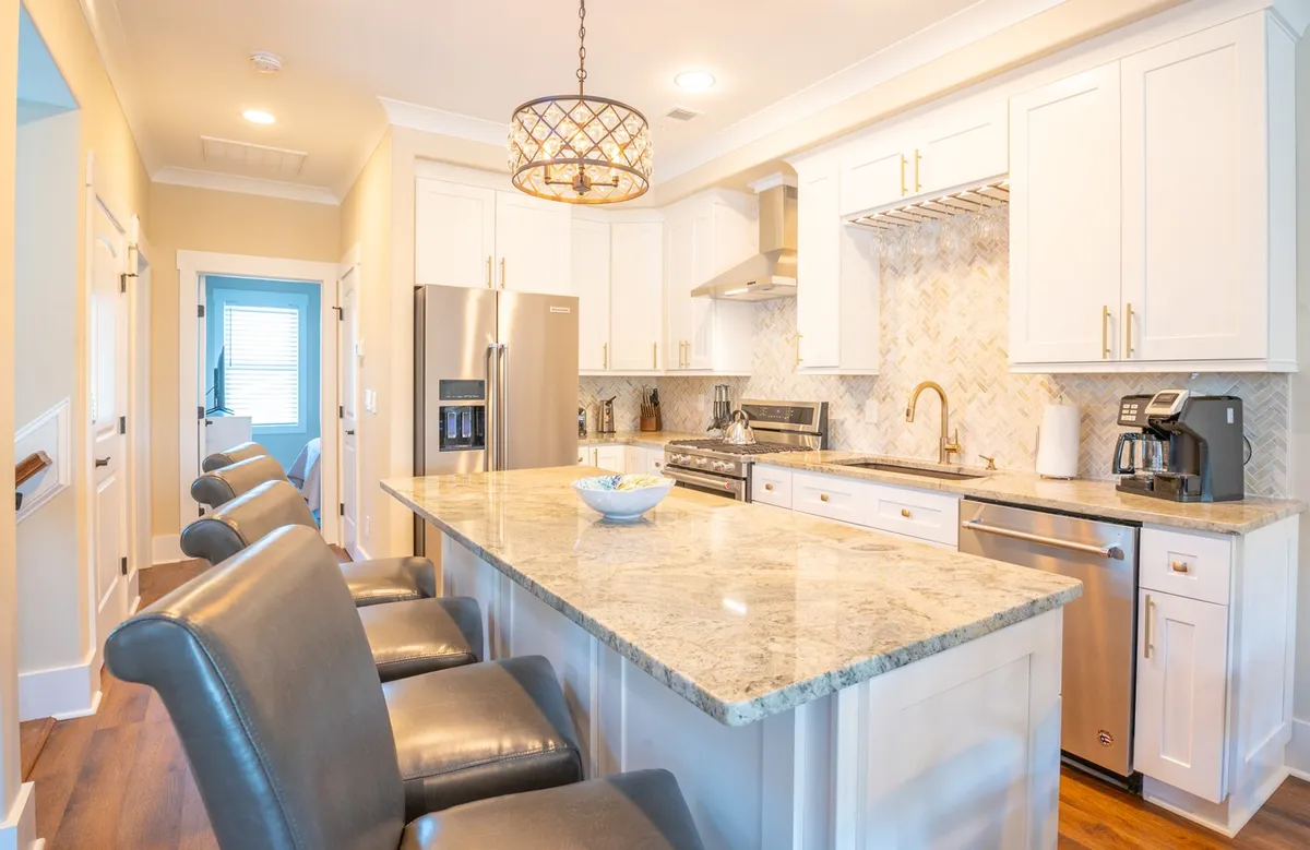 A bright, open-concept kitchen features a gleaming granite island, high-end stainless appliances, and stylish lighting, inviting guests to gather for cooking, entertaining, and sharing memorable moments together.
